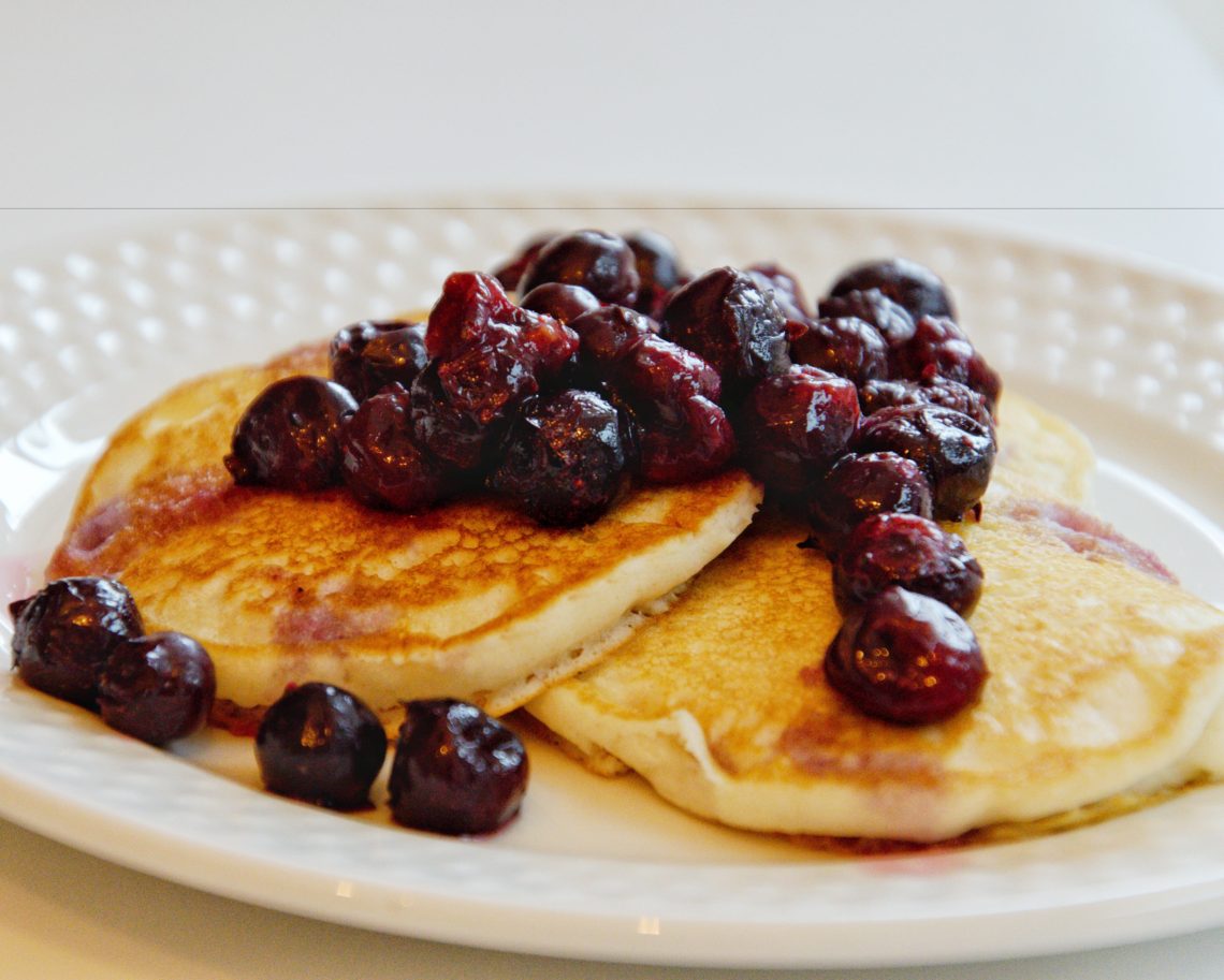 Pancakes topped with blueberry sauce.