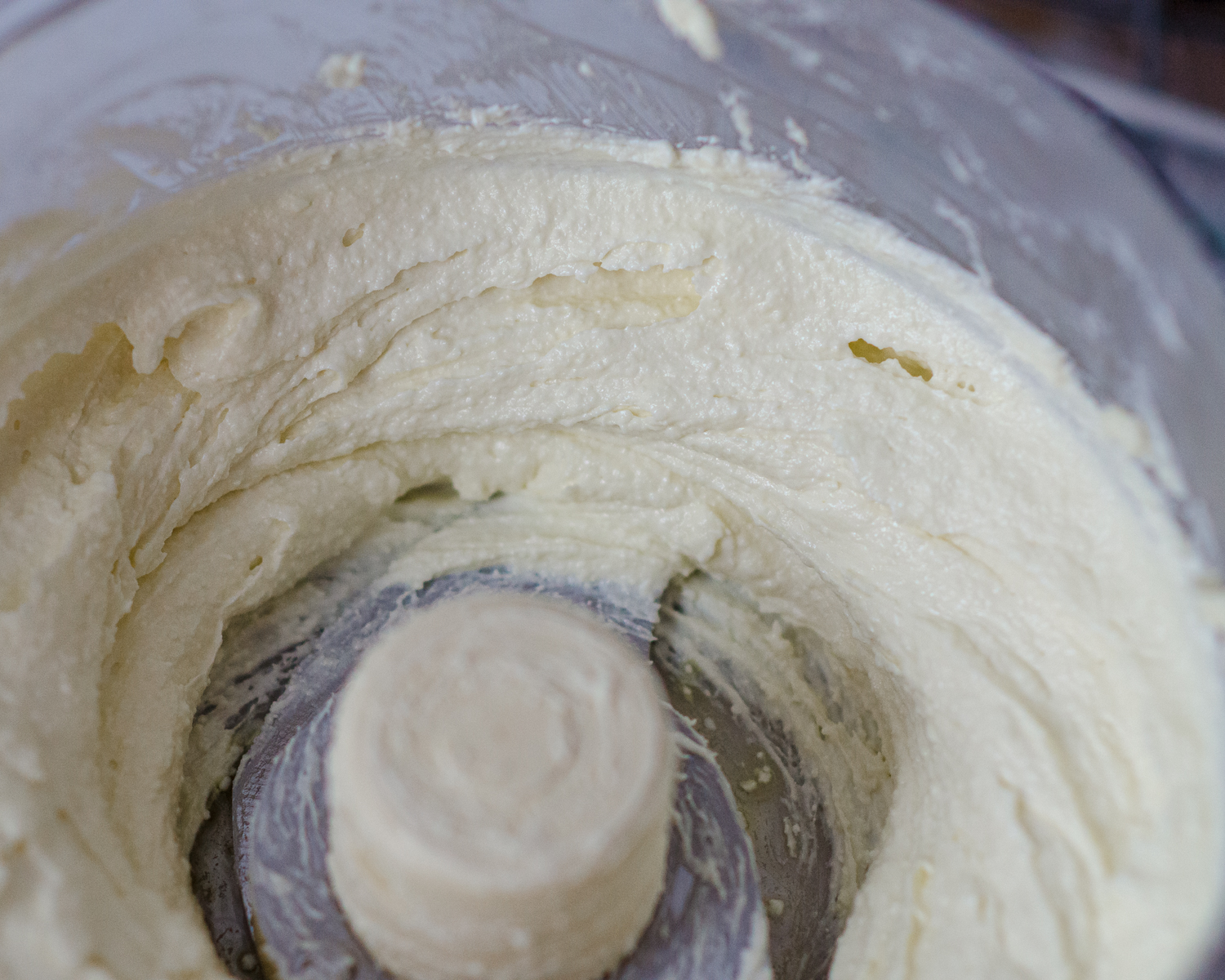 Creamy swirls of the whipped feta spread in the food processor bowl. 