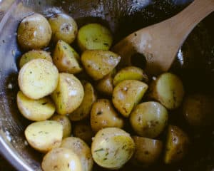Potatoes being tossed in duck fat and herbs
