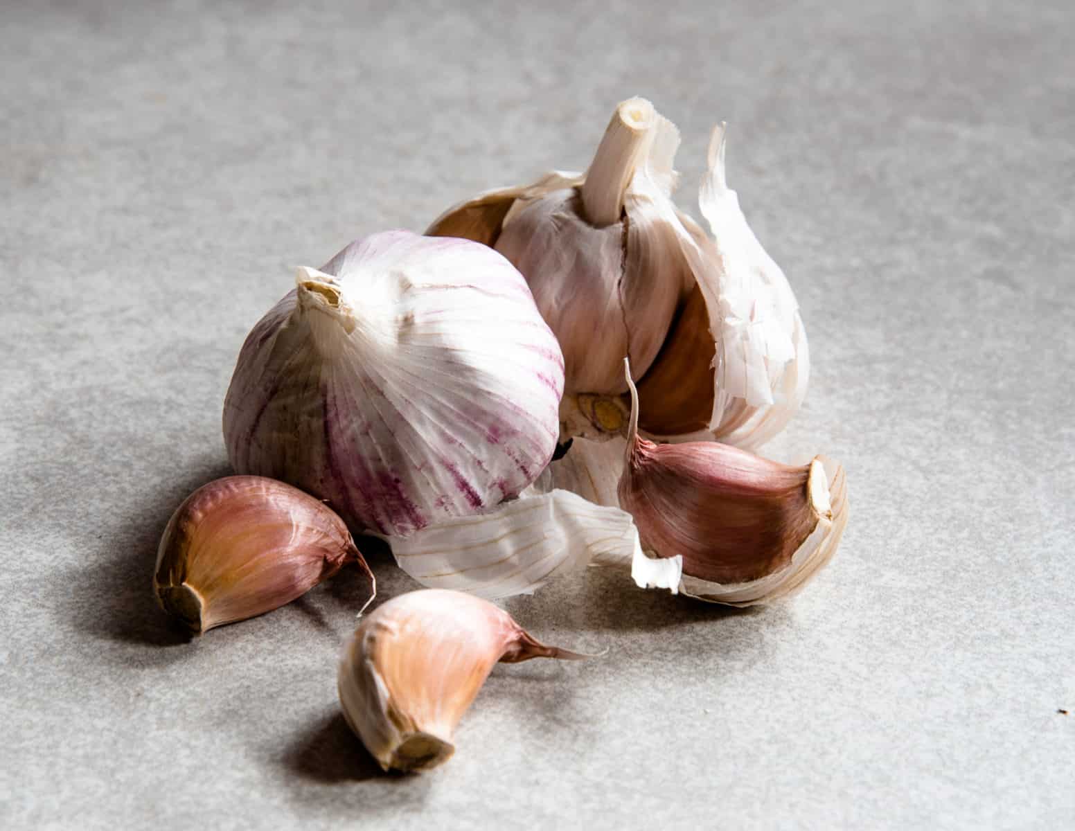 Garlic bulbs and cloves with shed peels falling off. 