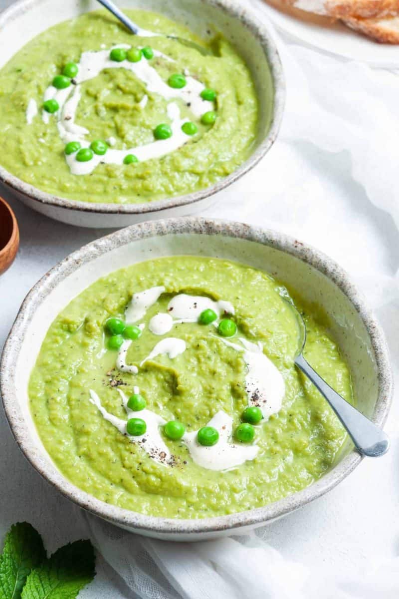 Bowl of pea and mint soup with spoons in the bowls. 