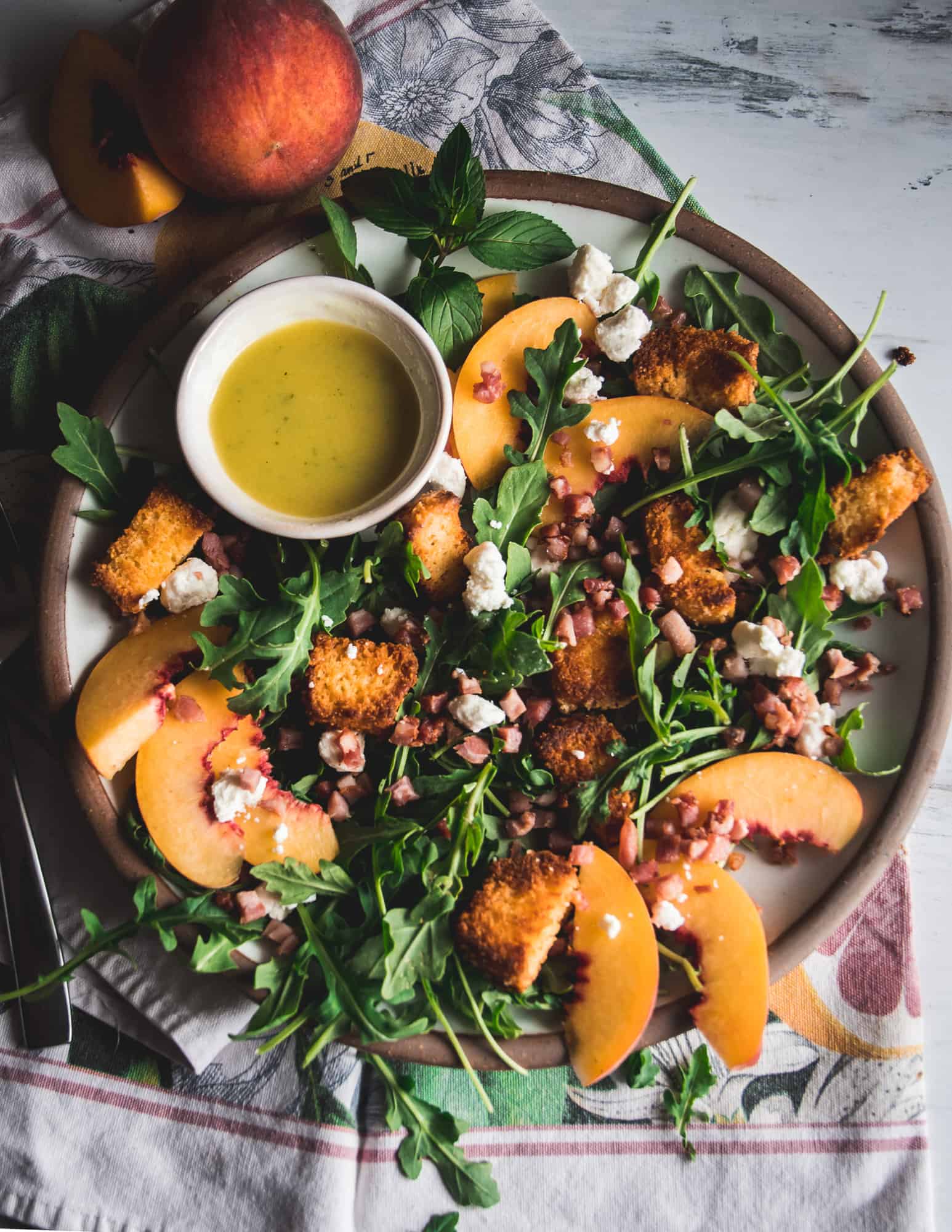 salad of arugula, peaches, goat cheese crumbles and croutons,