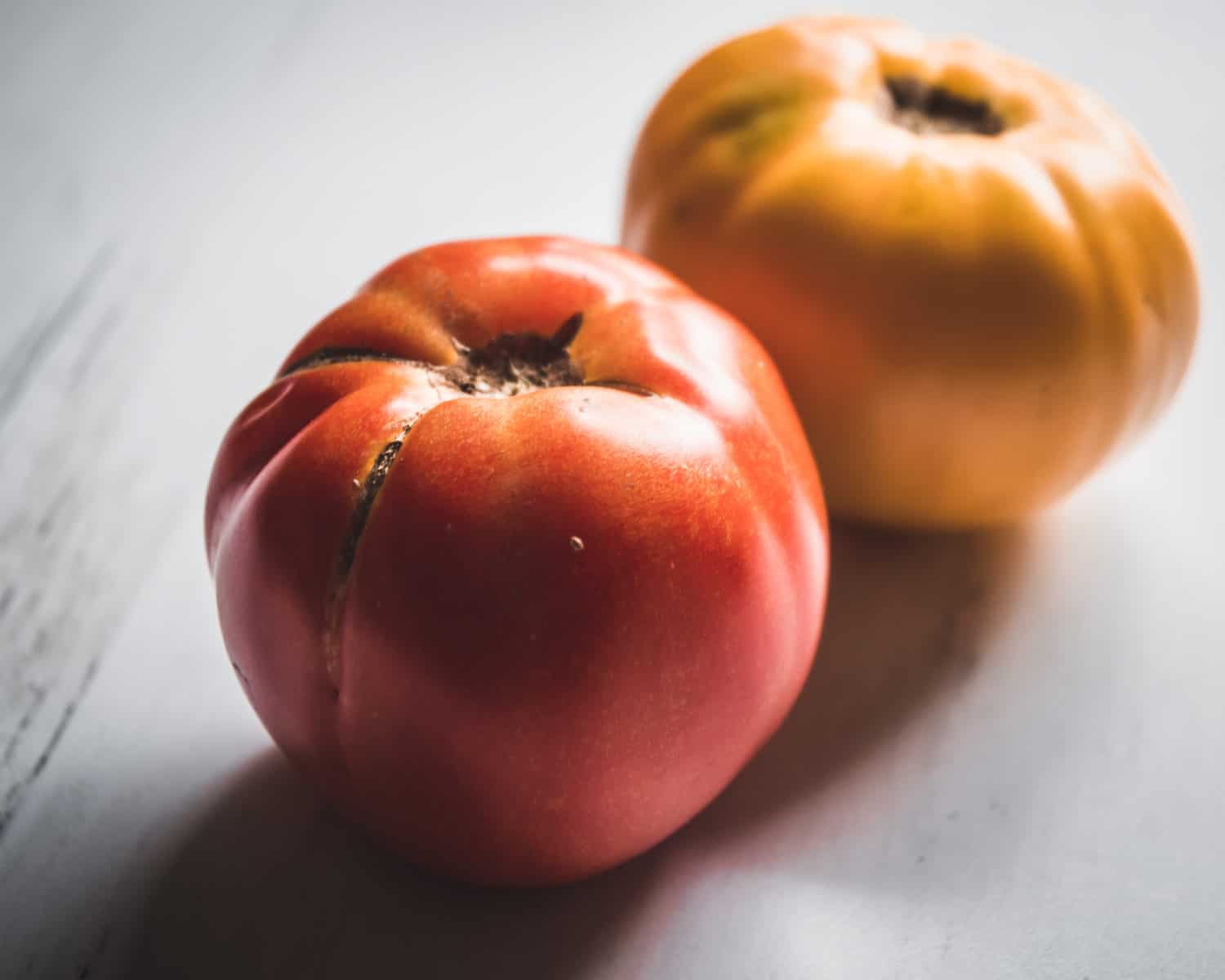 One red and one orange heirloom tomato. 