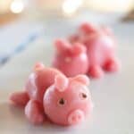 Two marzipan pig candies on a white table.