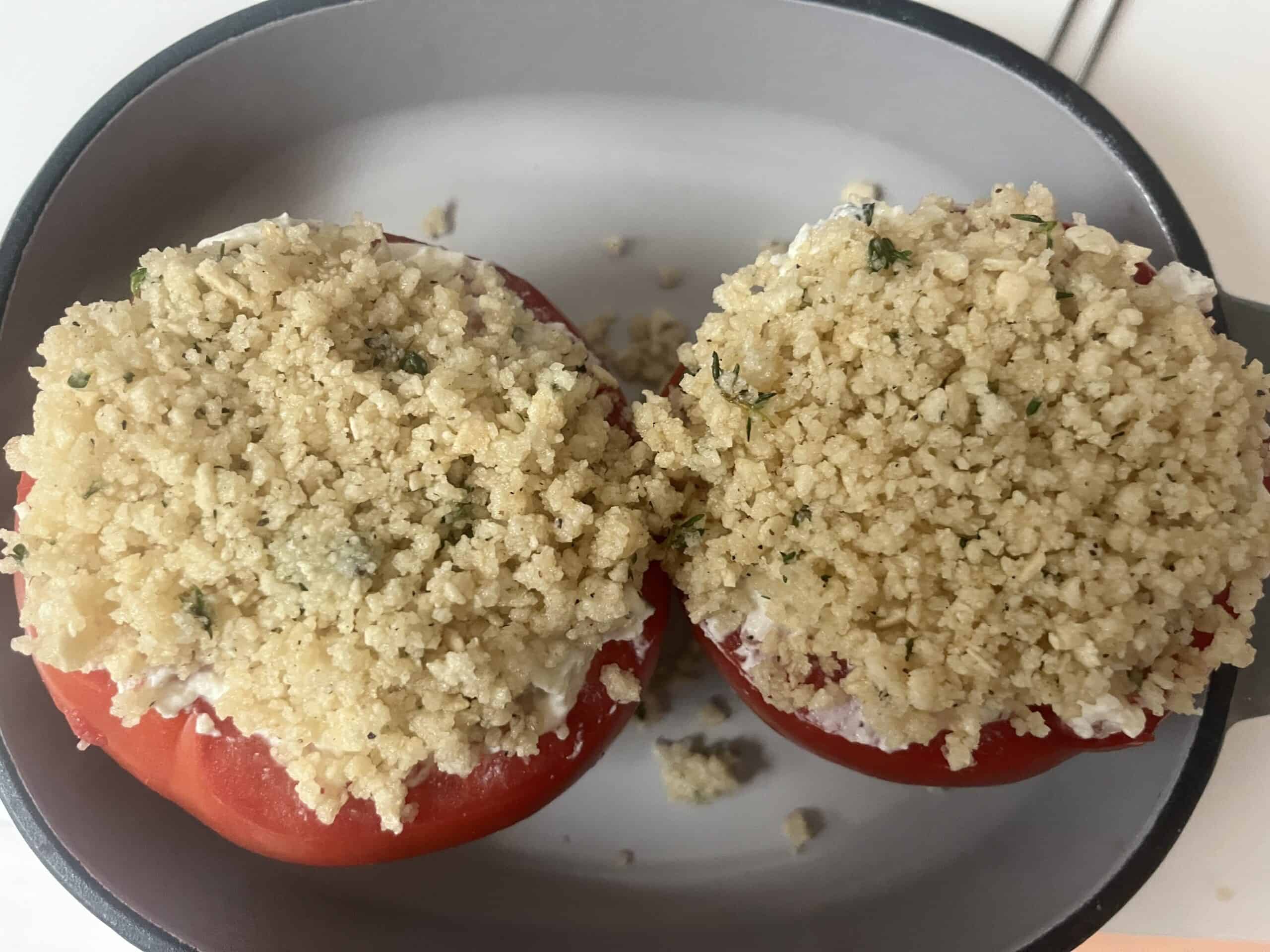 Unbaked stuffed tomatoes in a baking dish. 