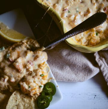 Shrimp dip with pepper slices and lemon for garnish.